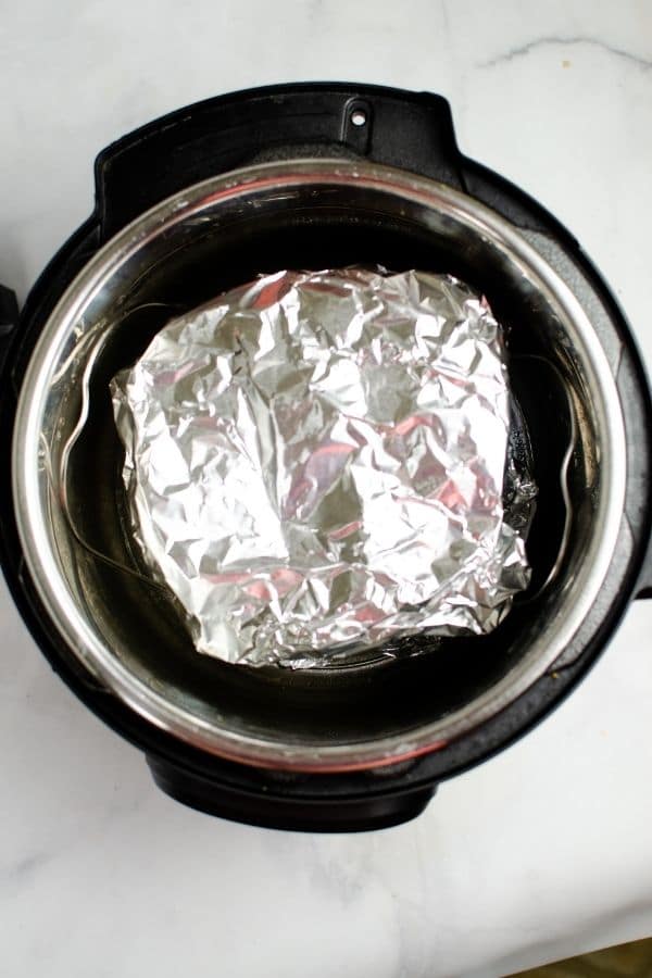 picture of instant pot with cheesecake bites wrapped in aluminum foil