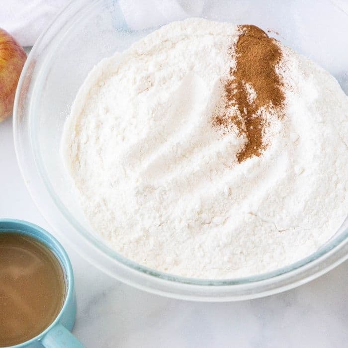 cake mix in a bowl with apple cider by it 