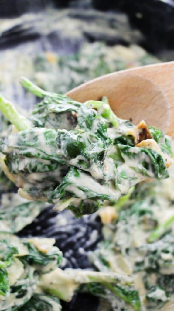 creamed spinach with wooden spoon 