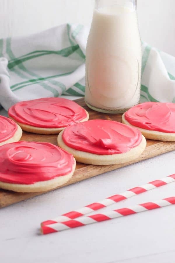 almond sugar cookies on tabl with milk jug behind it 