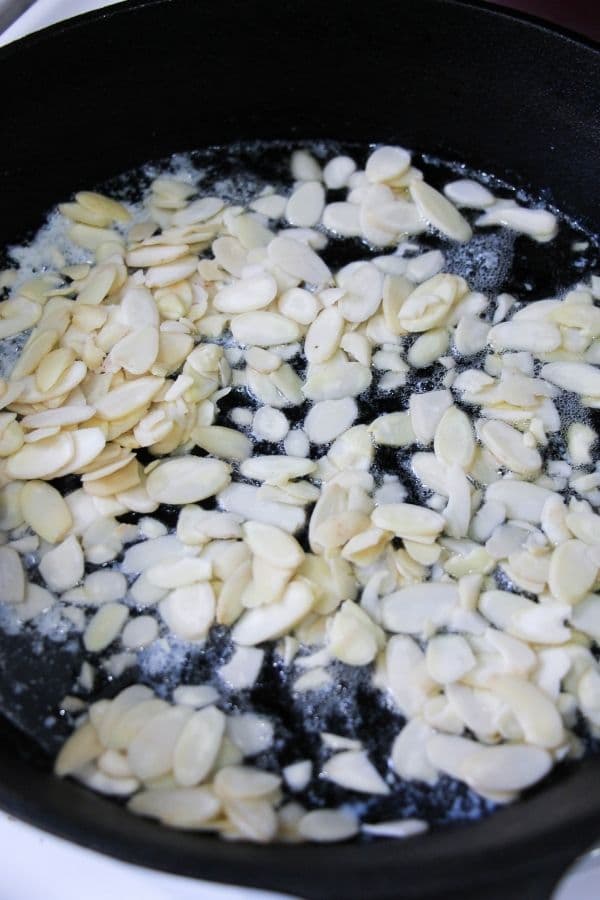 slivered almonds cooking in a pan 