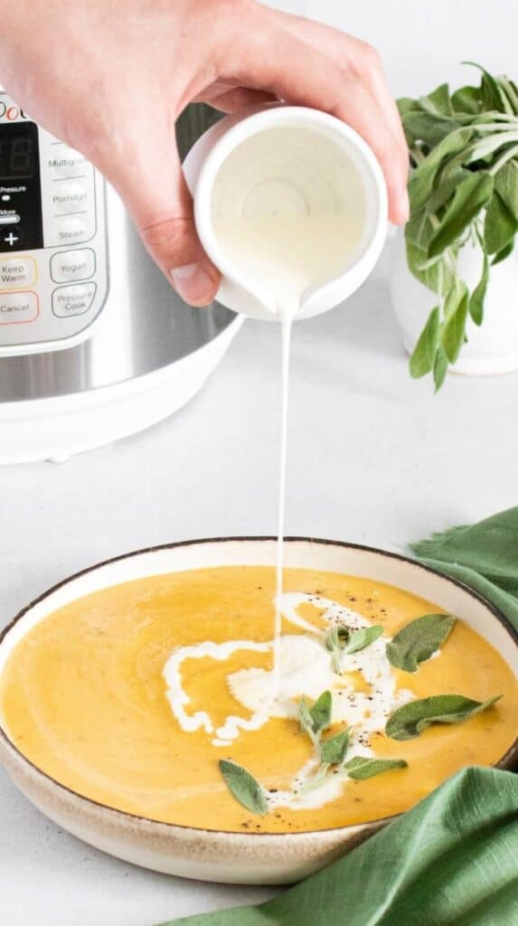 heavy cream pouring into butternut squash soup