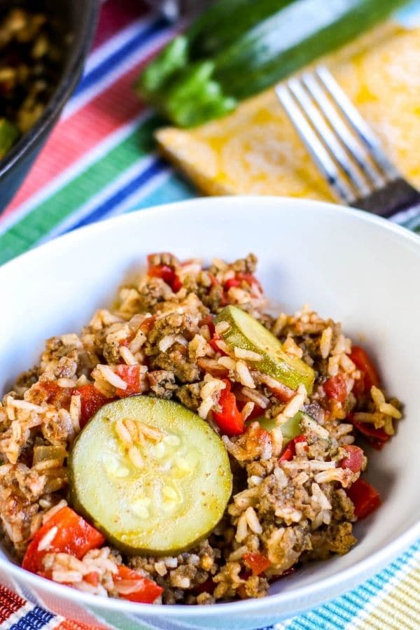 plate of beef, rice, and zucchini with bright colored towel behind it 