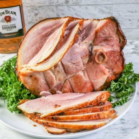 sliced ham on a platter with greens under it