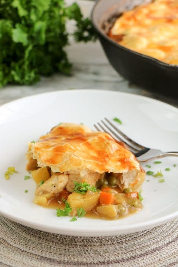 chicken pot pie on plate with pan behind it 