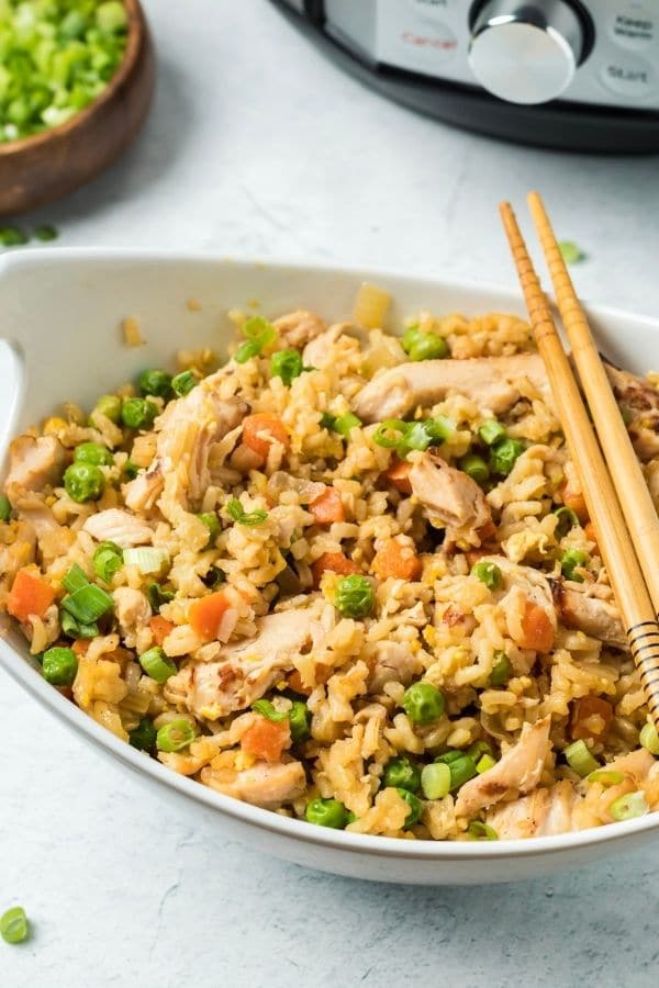 oval bowl of rice and chicken with chopsticks by it 