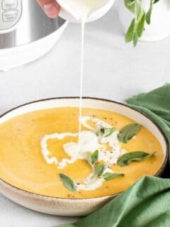 butternut squash soup with cream pouring in