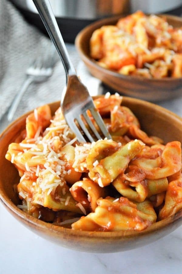 tortellini pasta in a bowl with a fork 