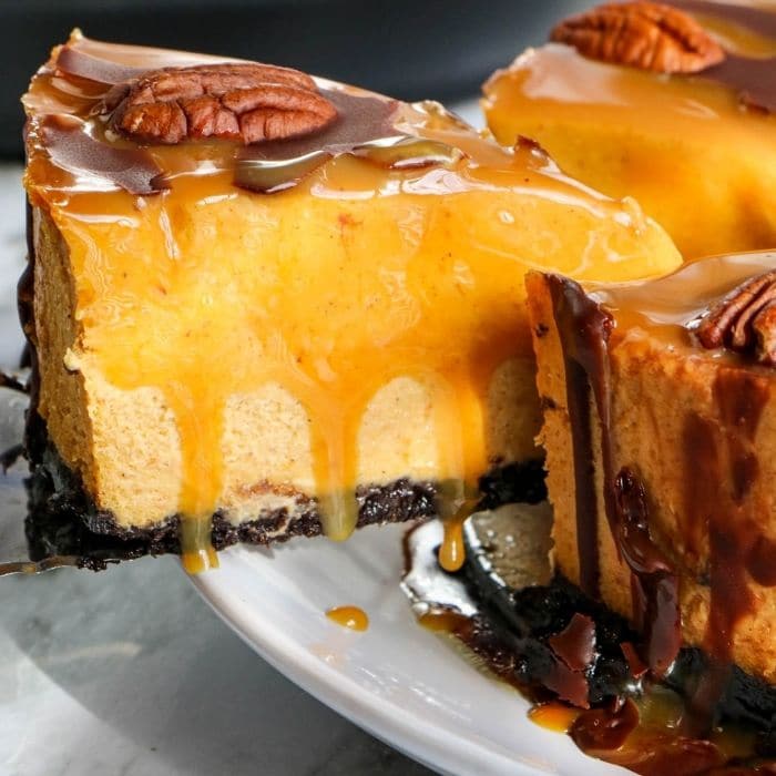 slice of turtle cheesecake coming out of whole cheesecake