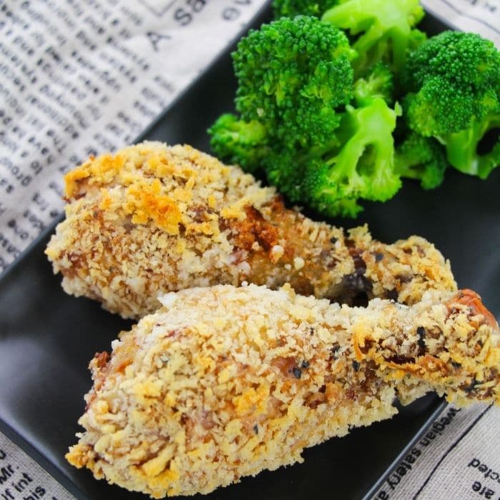 baked chciken legs on plate with broccoli on towel
