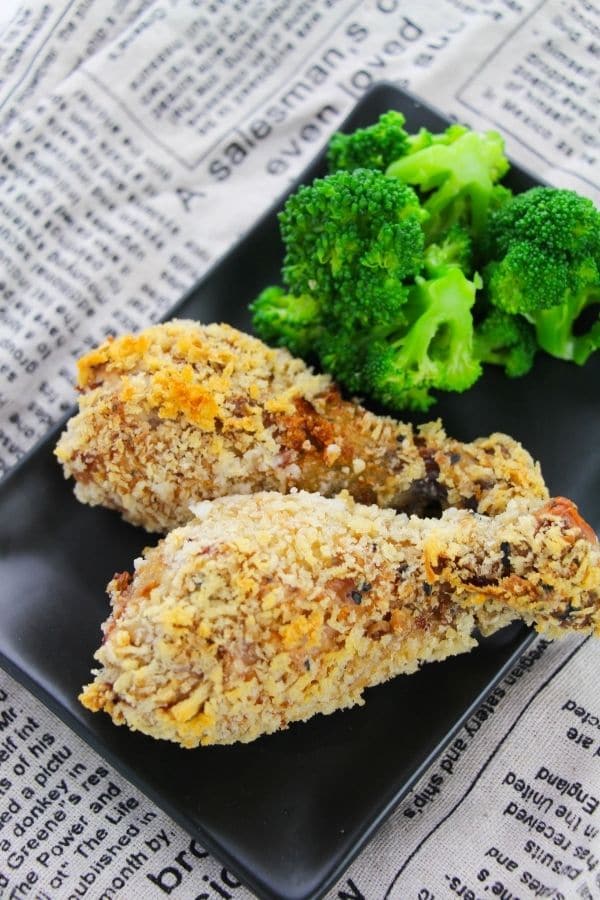 baked chicken on a black rectangle plate with broccoli - overhead shot 