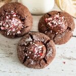 mint thumbprint cookies on table with milk behind it