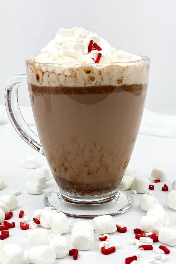 hot chocolate in a clear mug topped with whipped cream