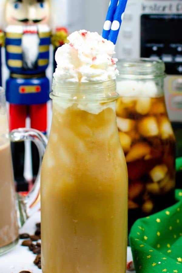 a small jar that is filled with a peppermint mocha coffee drink with nutcracker in background 