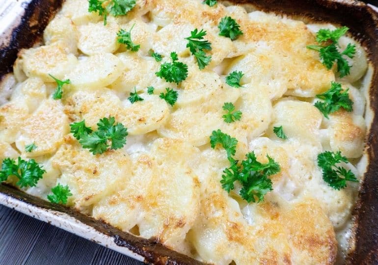 casserole with potatoes topped with parsley