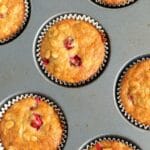 muffin tin with fresh cranberry muffins in it