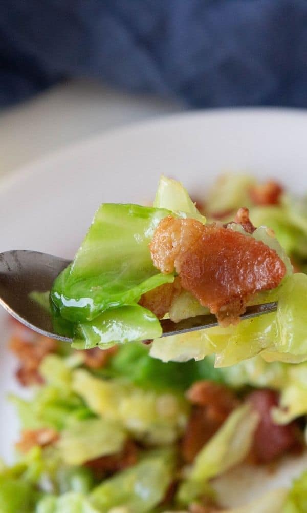 fork with fried cabbage and bacon on it 