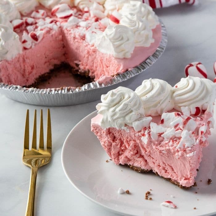 mint no bake cheesecake on plate with whole cheesecake behind it 