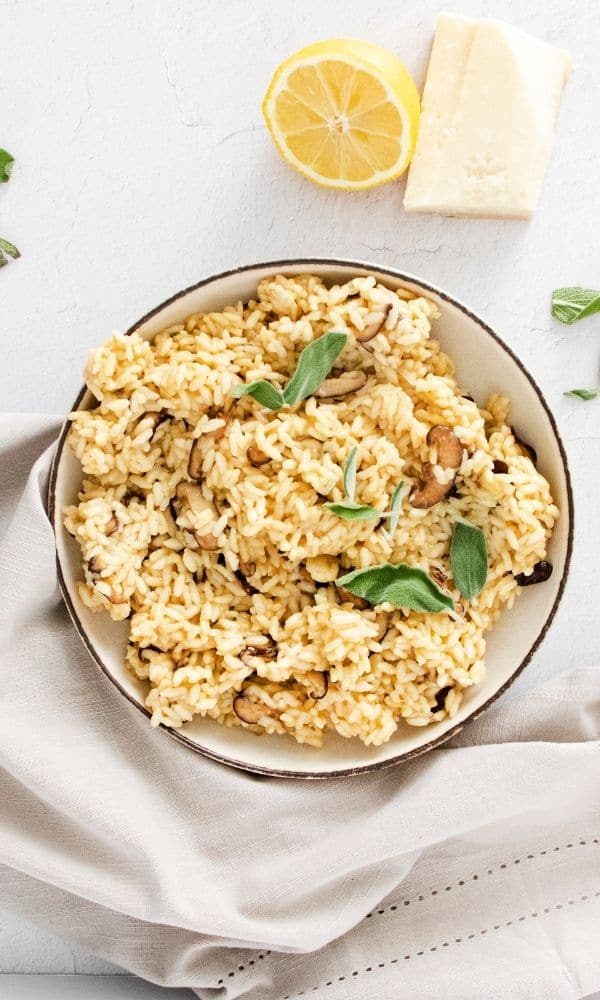 bowl of risotto on table with parmesan and lemon