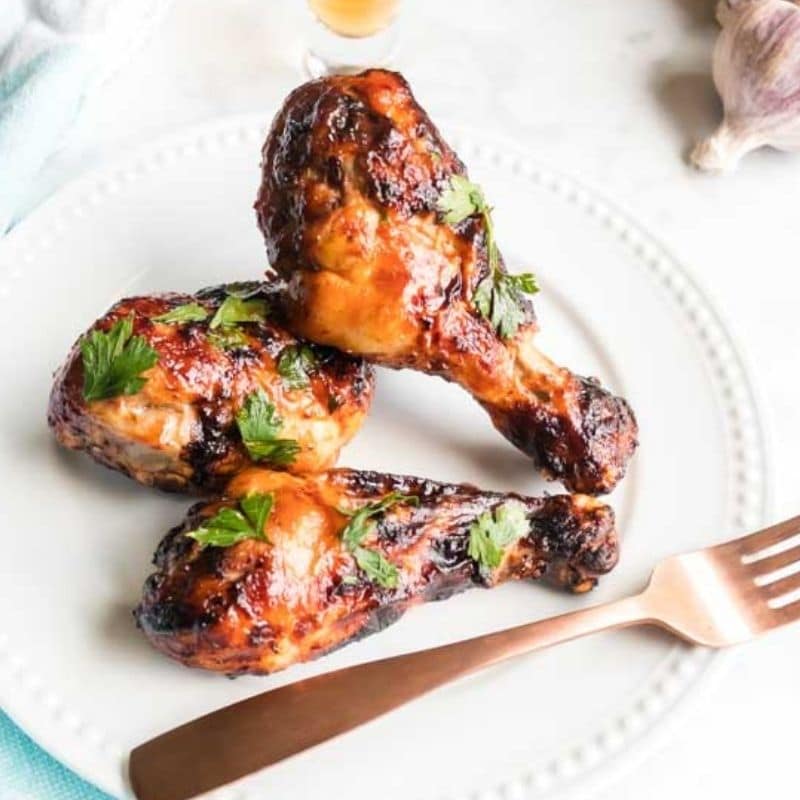 air fryer drumsticks on white plate with fork on table