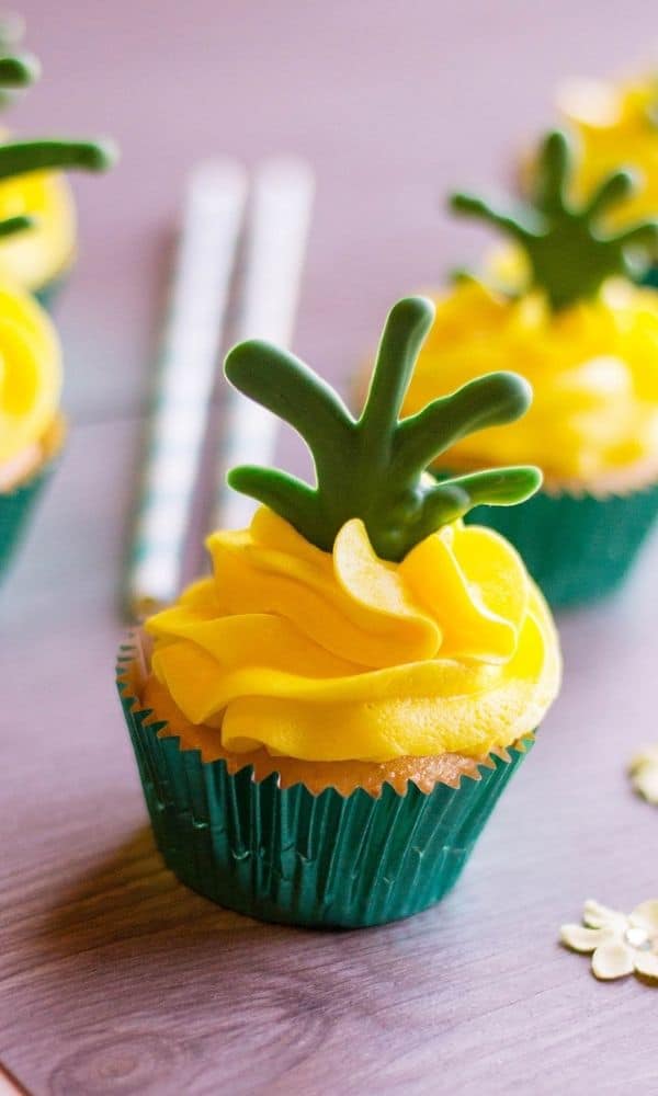 a pineapple cupcake on counter with yellow frosting