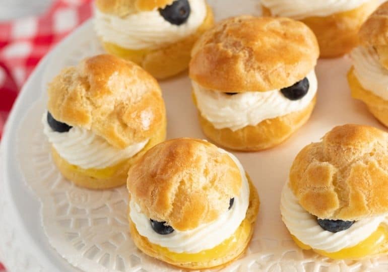 plate of lemon cream puffs with blueberries on it