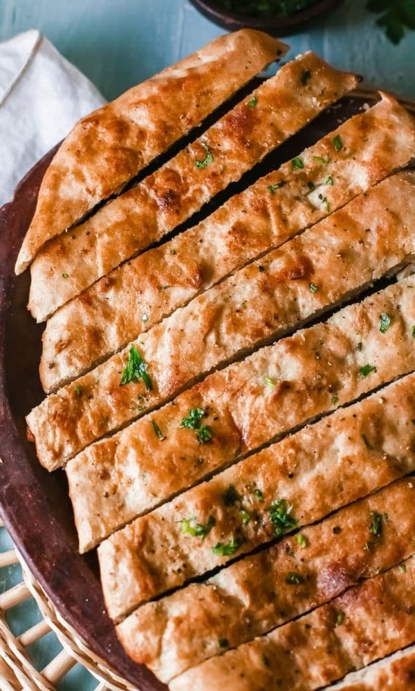 garlic bread on table sliced up on platter 