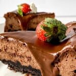 slice of chocolate cheesecake on plate with strawberry on top