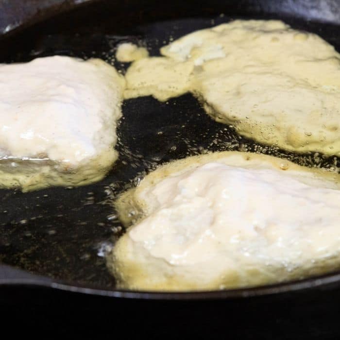 skillet with fish being fried 