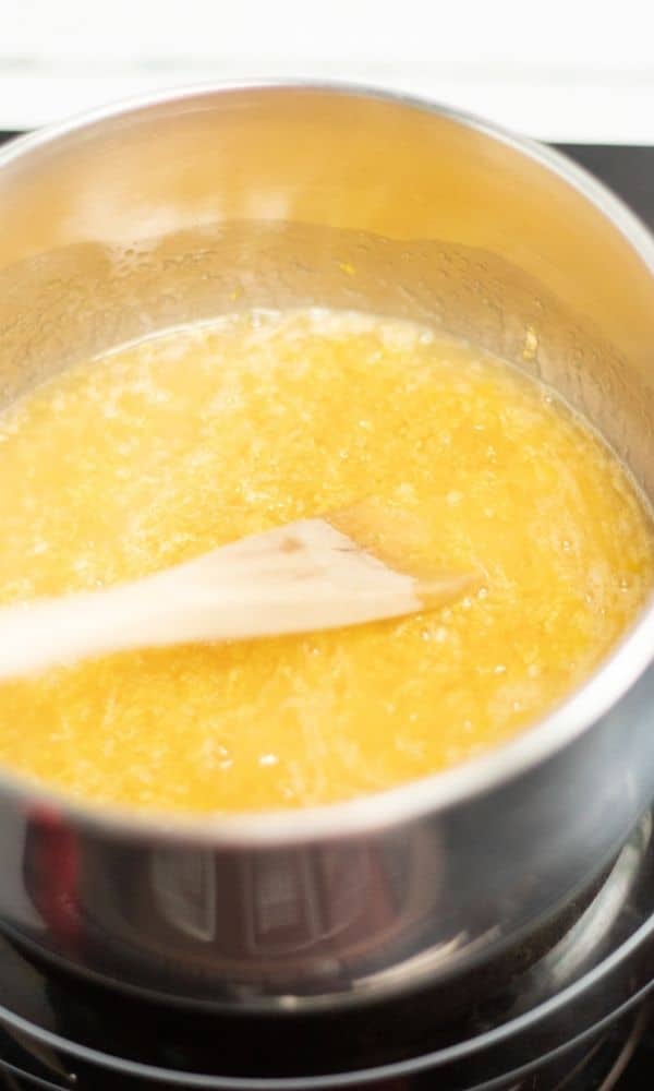 stirring lemon curd in saucepan 