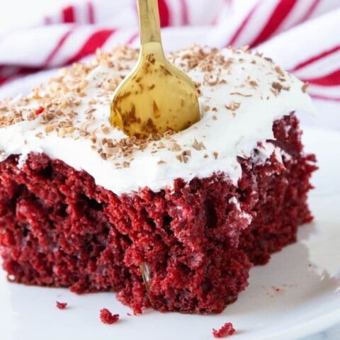 gold fork in poke cake on white plate
