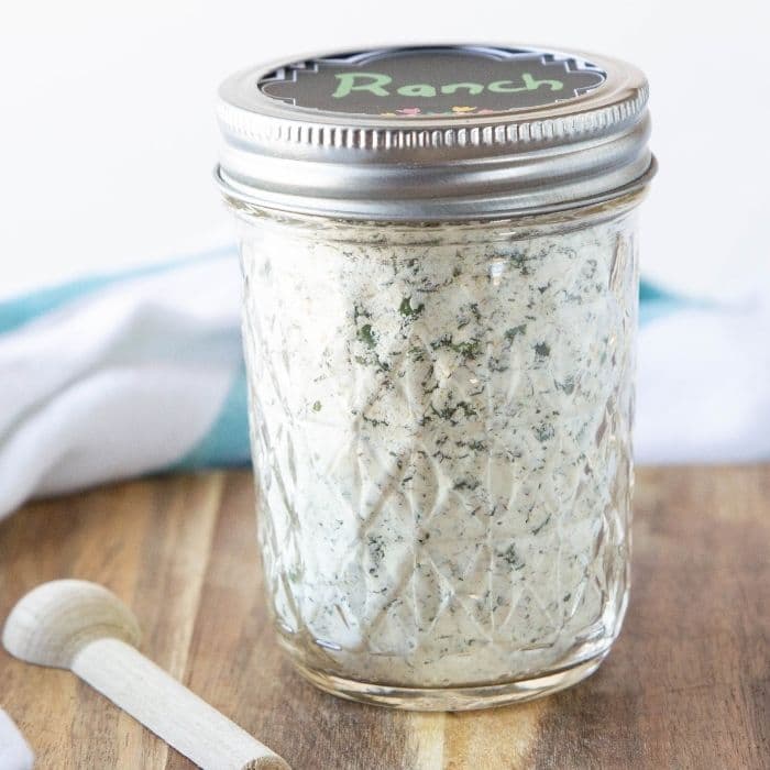 dry ranch mix in a mason jar with wooden spoon beside it 