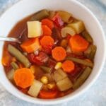 veggie soup in a bowl with spoon in it