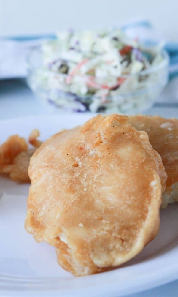 fish on plate with coleslaw by it 