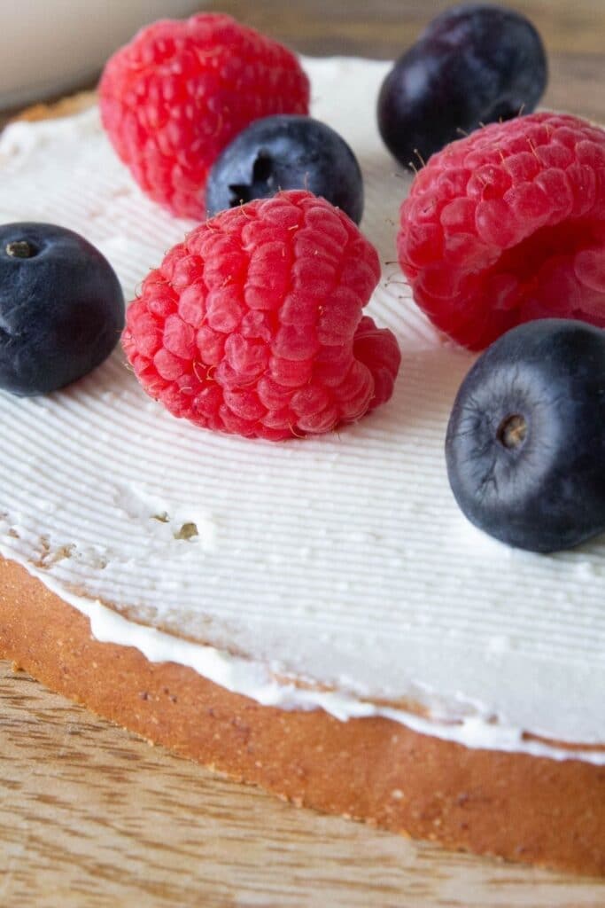 cream cheese spread on toast with fresh berries on top 