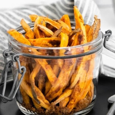sweet potato fries in a jar with towel behind them