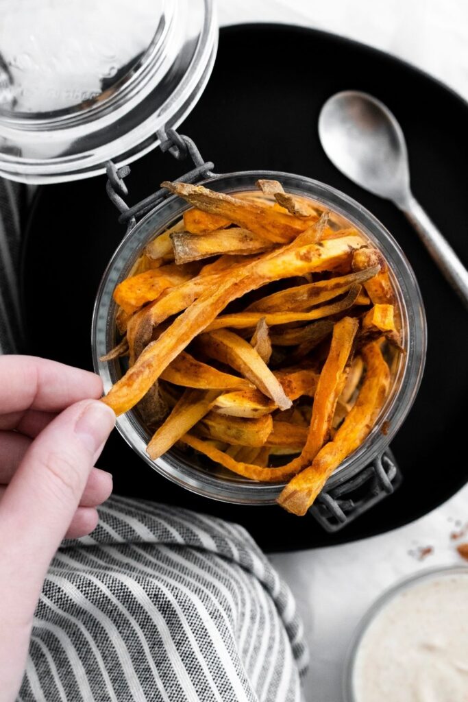 grabbing a sweet potato out of container to eat 