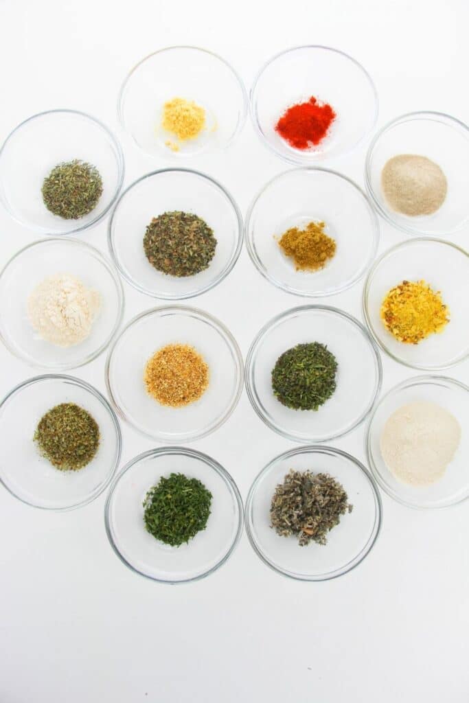 seasonings in glass bowls on white table