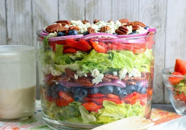 side view of a layered salad in glass bowl 