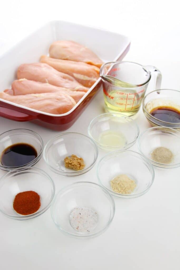 ingredients for baked chicken breast on a white counter 