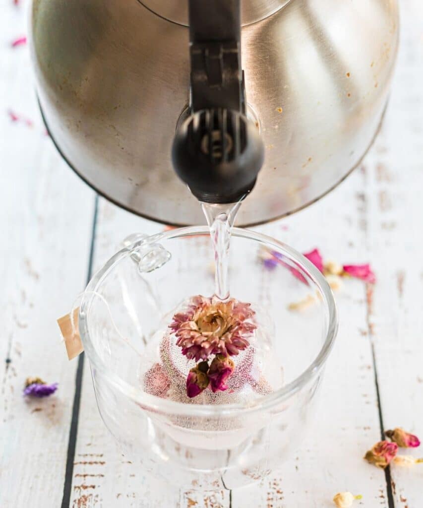 pouring hot water over tea bomb in cup 