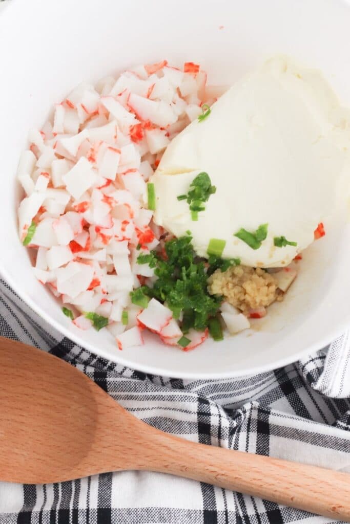 crab rangoon ingredients in a bowl with spoon by it 