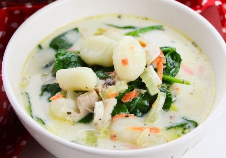 chicken gnocchi soup in a white bowl on table