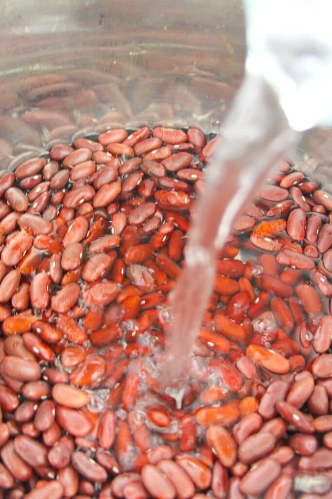 pouring water into dried kidney beans 