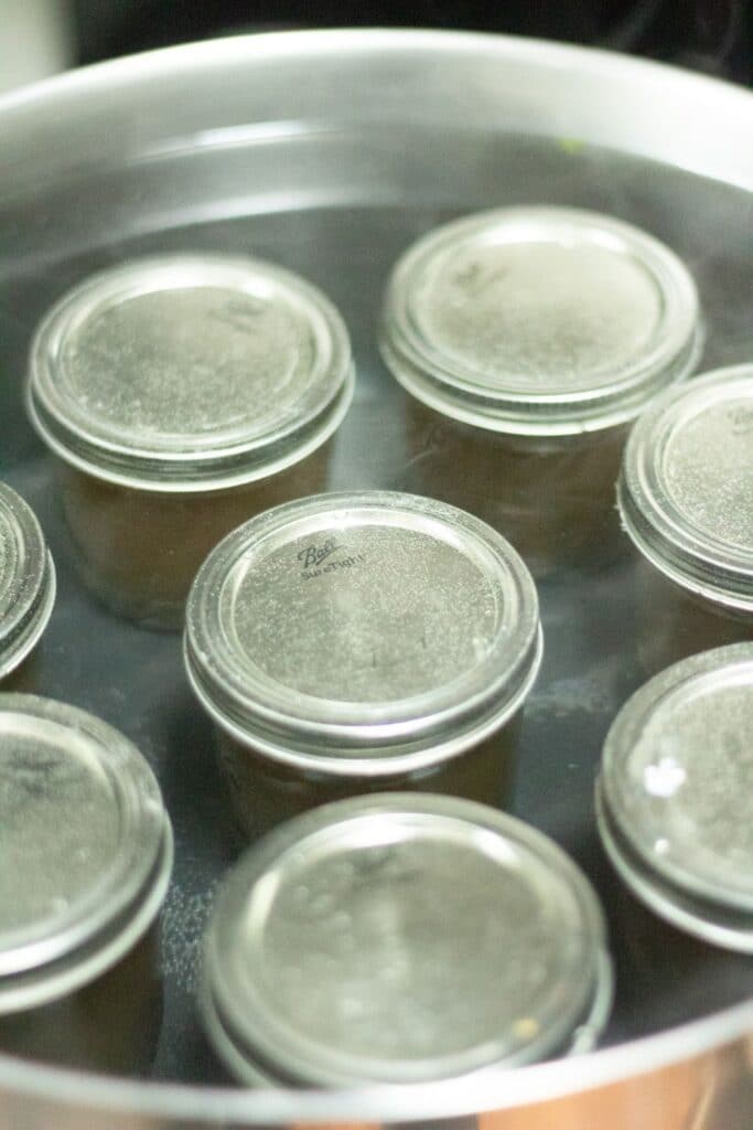 flower jelly in jars in a canning pot