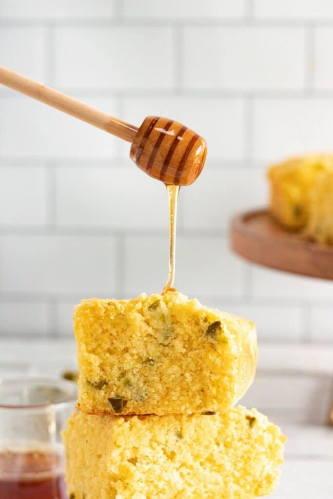 honey cornbread with honey getting drizzled on top 