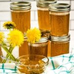 cans of jelly on counter with dandelions by it