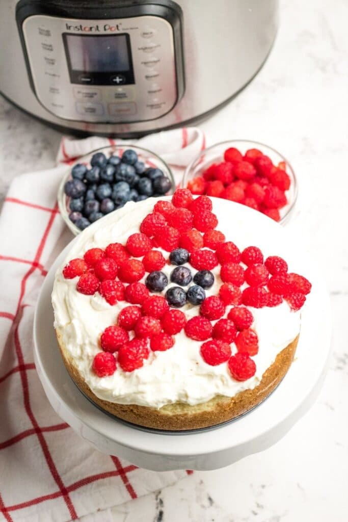 overhead view of a cheesecake with berries on top 