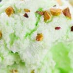 close up of pistachio ice cream with nuts on top