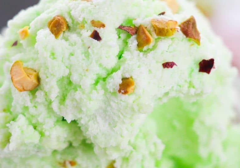 close up of pistachio ice cream with nuts on top